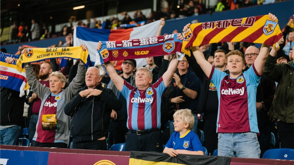 球迷在看台举起新老球星球衣的对比场景